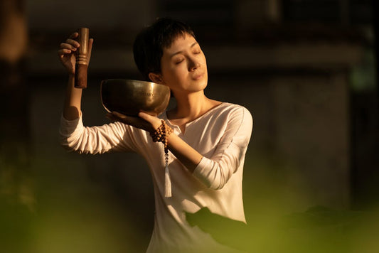 A serene woman meditates with a singing bowl, embracing tranquility and mindfulness.